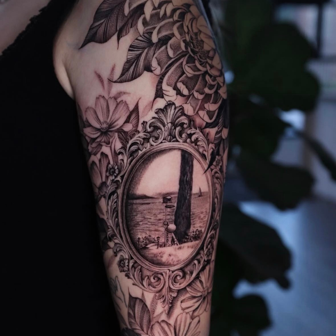 Intricate arm piece with mirror reflection and florals - Black and grey realism by Keila Soto